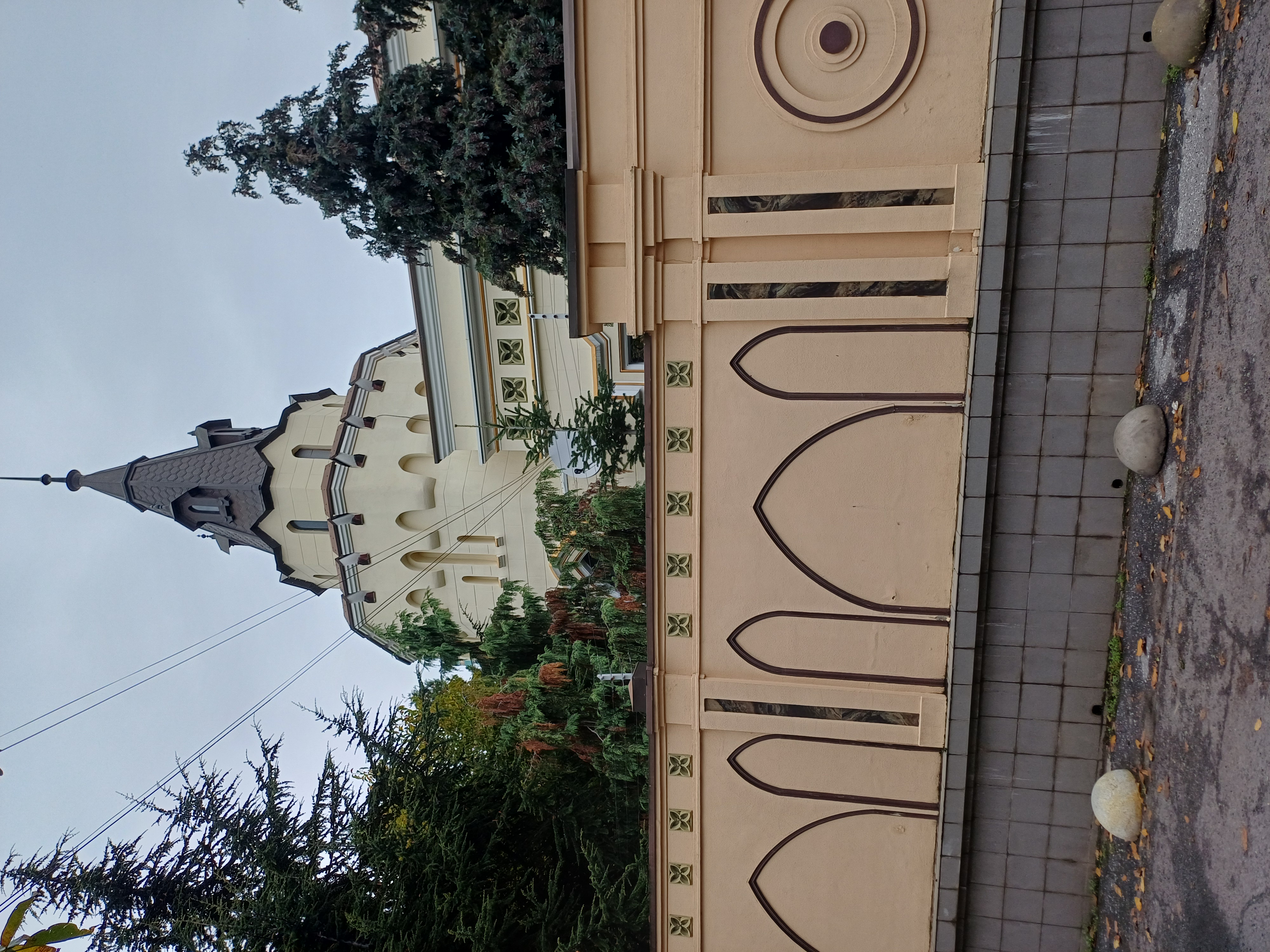 Вежа зі шпилем у будівлі колишньої амбулаторії за огорожею